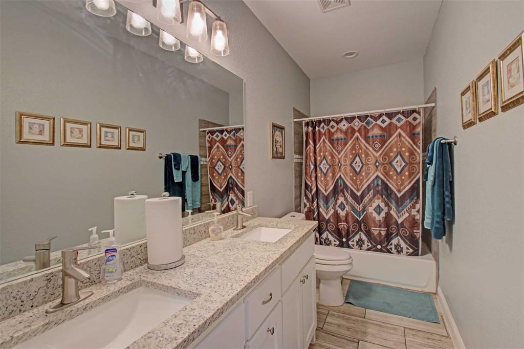 8789 Hutcheson Hill Road Springtown, TX 76082 - Photo 24 of 32 a bathroom with a granite countertop sink and a mirror