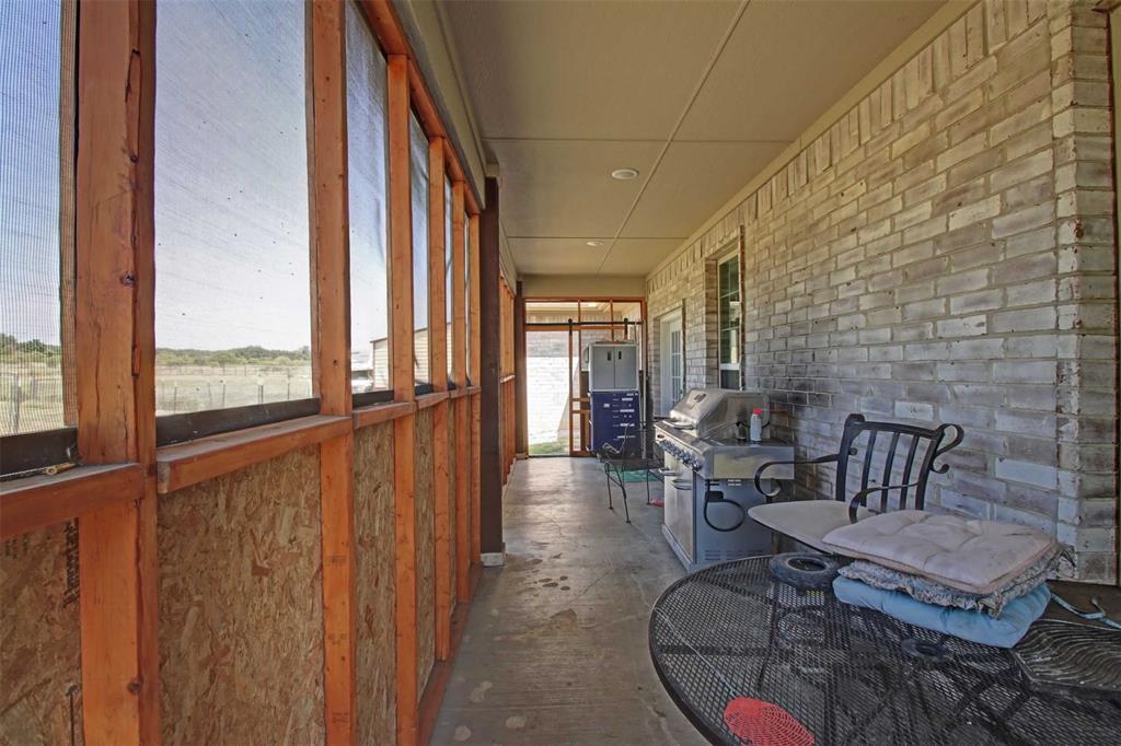 8789 Hutcheson Hill Road Springtown, TX 76082 - Photo 25 of 32 a living room with furniture and a floor to ceiling window