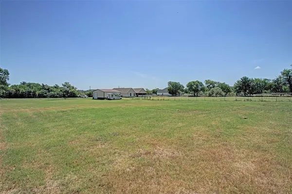 a view of a field with an trees in the background