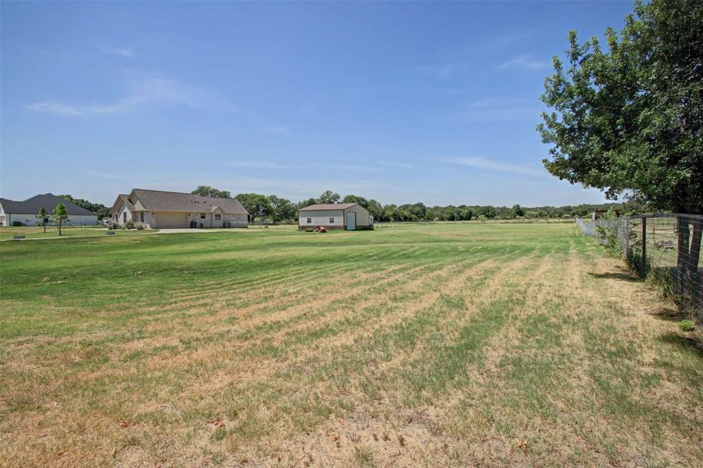 8789 Hutcheson Hill Road Springtown, TX 76082 - Photo 29 of 32 a view of a field with an trees in the background
