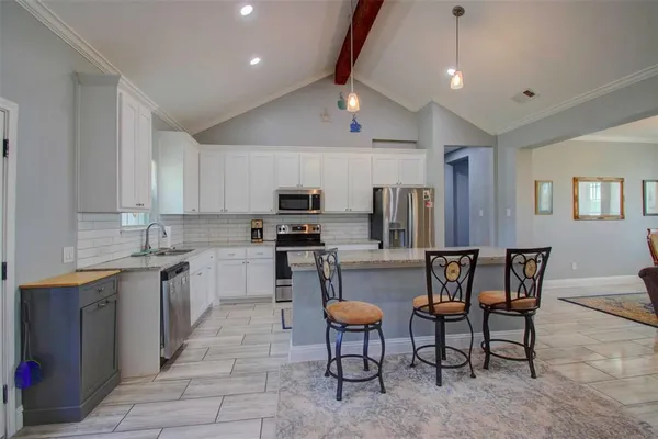 a kitchen with stainless steel appliances kitchen island granite countertop a sink and cabinets