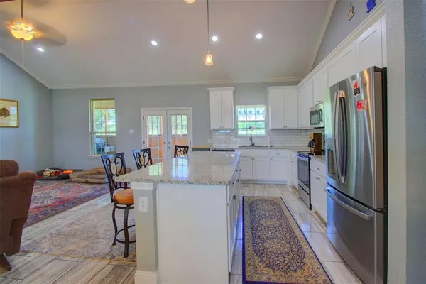 a kitchen with stainless steel appliances granite countertop a refrigerator and a sink