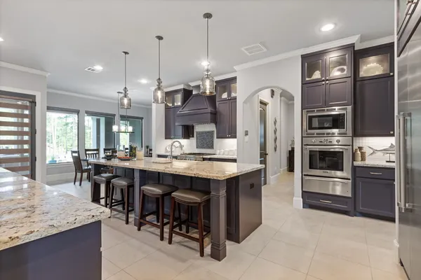 a large kitchen with a counter space a sink appliances and cabinets