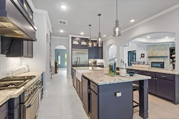 a large kitchen with kitchen island a sink a center island a stove and a dining table view
