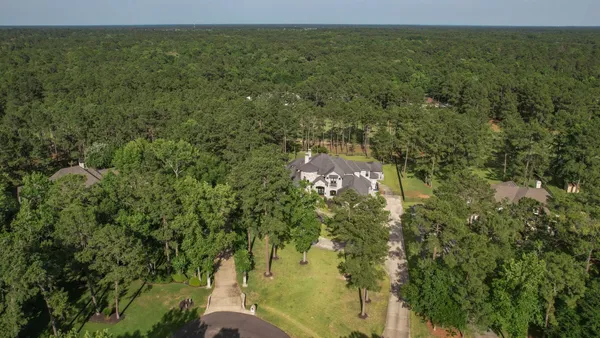 an aerial view of house with yard and mountain view in back