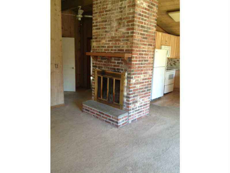 85 Sloop Street Jamestown, RI 02835 - Photo 3 of 6 Living Room. Brick Fireplace Creates A Cozy Feeling