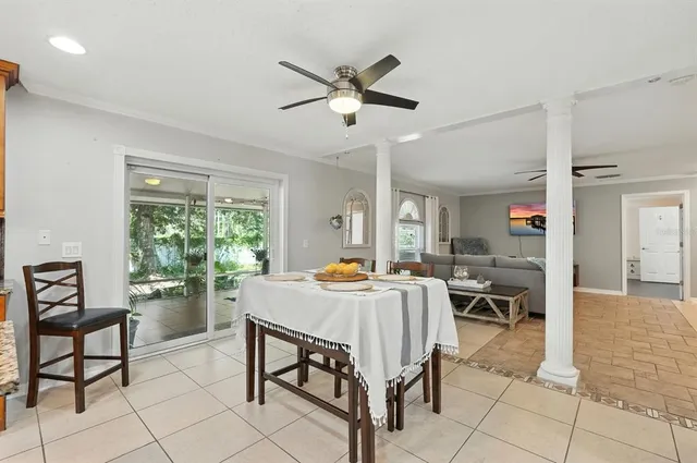 a living room with furniture kitchen view and a large window