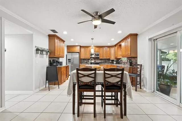 a kitchen with stainless steel appliances granite countertop wooden cabinets a sink dishwasher a stove and a refrigerator with wooden floor