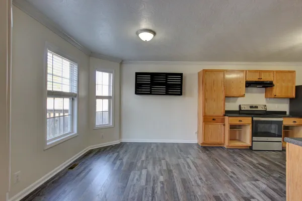 a kitchen with granite countertop a refrigerator and a stove top oven