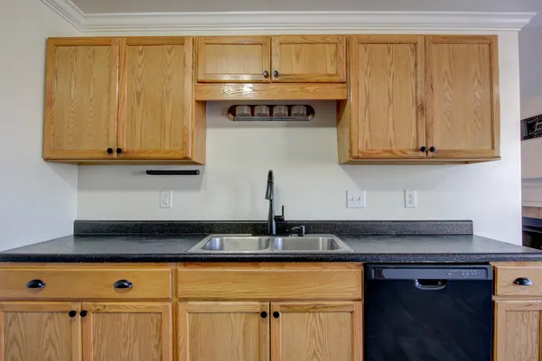 a kitchen with stainless steel appliances granite countertop white cabinets and a stove top oven