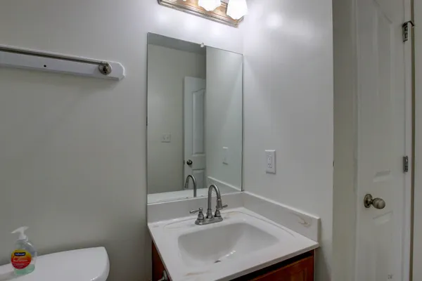 a bathroom with a sink toilet and a mirror