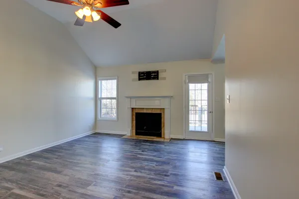 a view of a livingroom with a fireplace wooden floor and windows