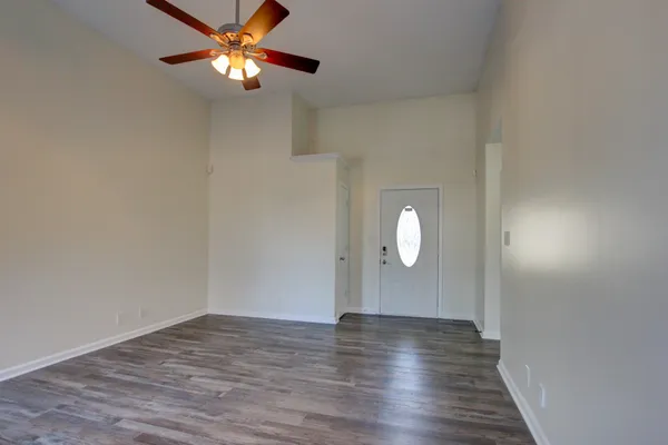 a view of an empty room with wooden floor