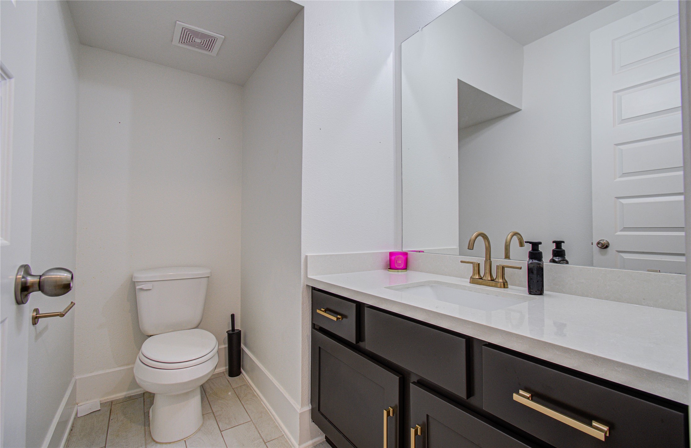 4211 Limestone Terrace Manvel, TX 77578 - Photo 15 of 33 This bathroom features a modern design with a sleek vanity, gold fixtures, and a large mirror. It has a neutral color palette, providing a clean and elegant look.
