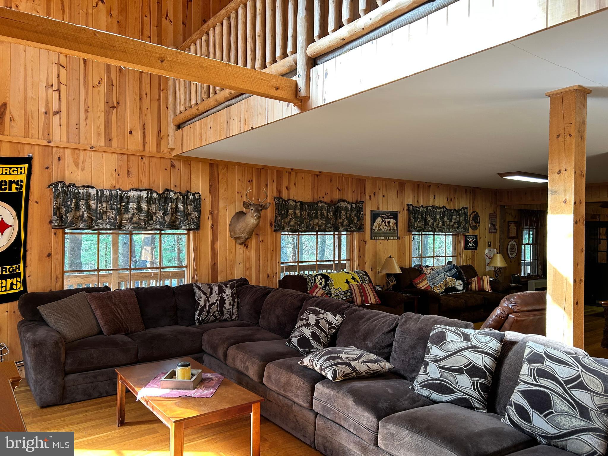 385 Elk Creek Road Aaronsburg, PA 16820 - Photo 24 of 89 a living room with furniture a large window and a chandelier