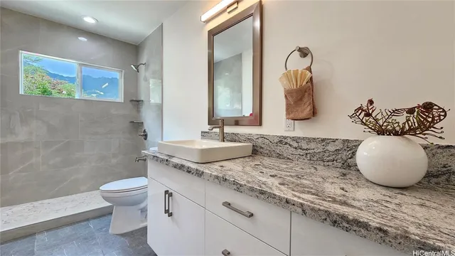 a bathroom with a granite countertop sink and a mirror