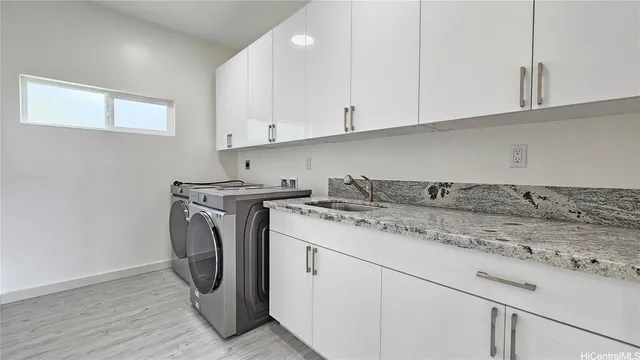 a utility room with sink dryer and washer