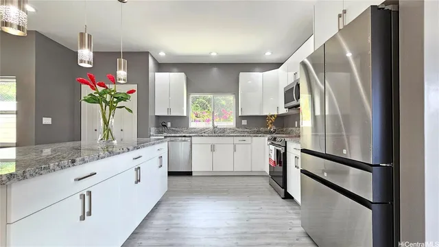 a kitchen with white cabinets and stainless steel appliances