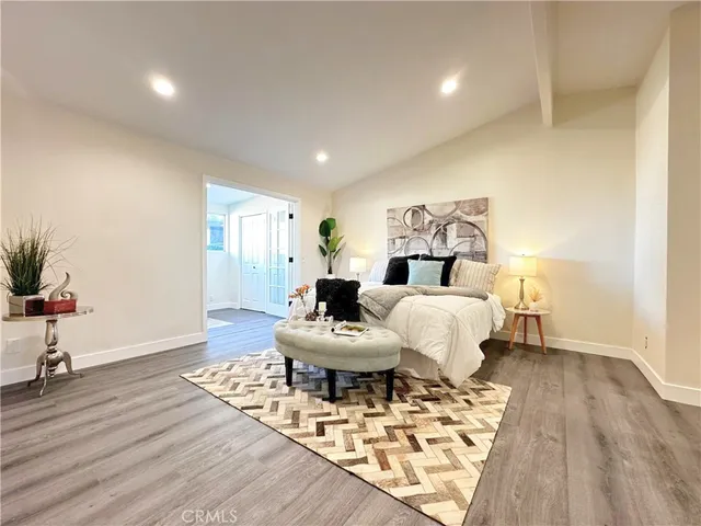 a living room with furniture a wooden floor and a potted plant