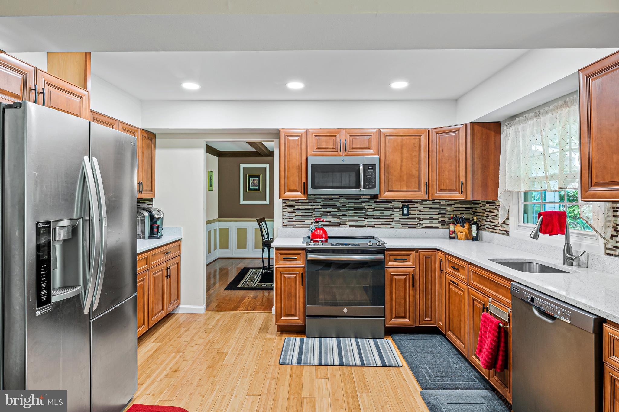 12128 Long Ridge Lane Bowie, MD 20715 - Photo 11 of 39 a kitchen with stainless steel appliances a refrigerator sink and wooden cabinets