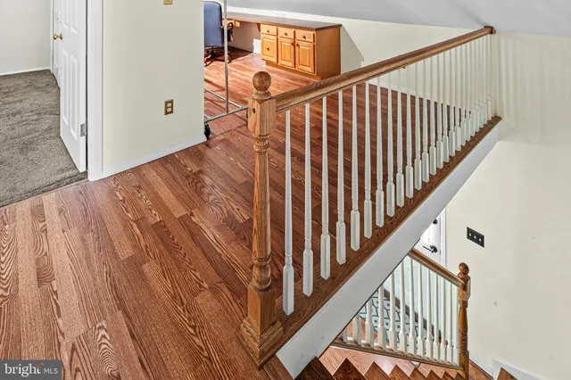 a view of staircase with railing and white walls