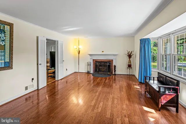 a view of empty room with wooden floor and fireplace