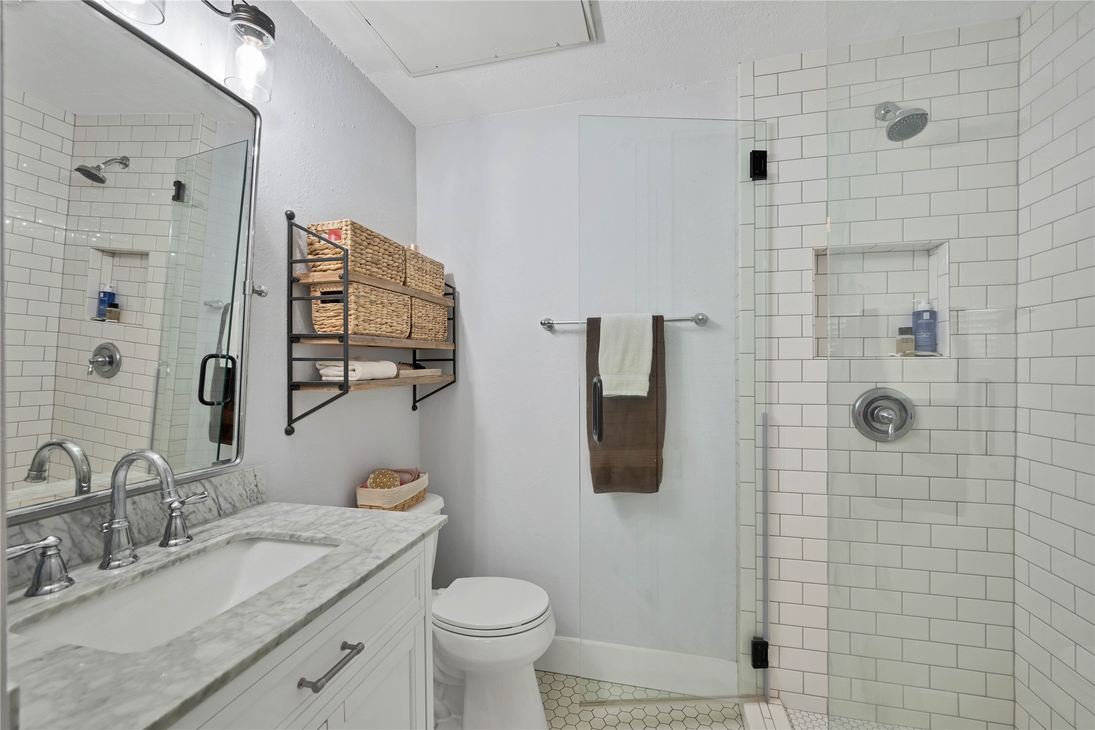 2605 Enfield Road, Unit 221 Austin, TX 78703 - Photo 15 of 30 Updated Bathroom 1 features marble counter tops, frameless glass shower with shampoo niche and bench seat, and hexagon tile floor.