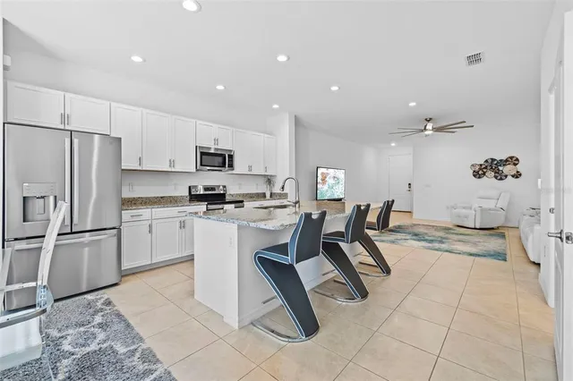a kitchen with granite countertop white cabinets and a stove top oven