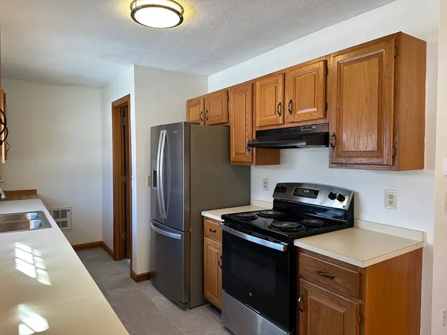 a kitchen with stainless steel appliances granite countertop a refrigerator sink and stove