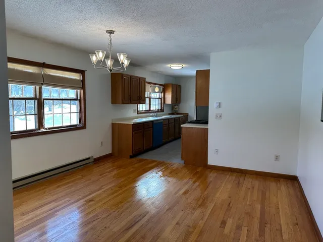 a view of a kitchen with wooden floor and stainless steel appliances