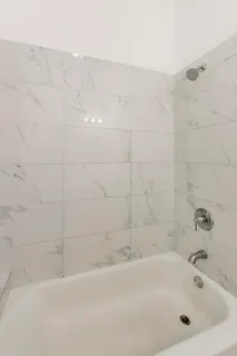 a white bath tub sitting next to a white sink and vanity