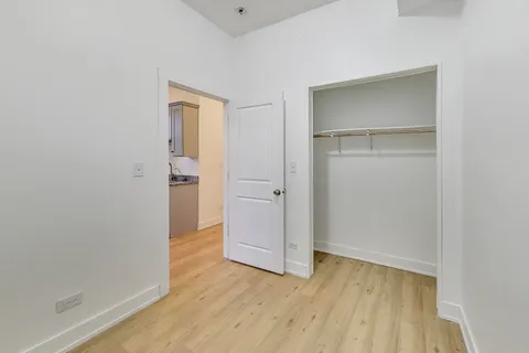 an empty room with wooden floor & closet