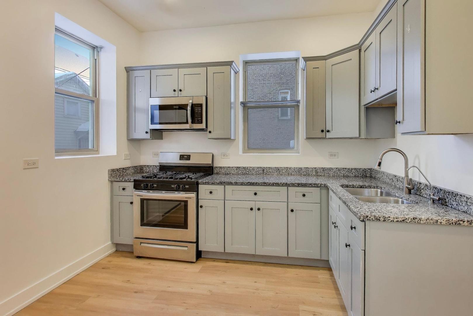1908 West 48th Street, Unit 1R Chicago, IL 60609 - Photo 7 of 17 a kitchen with granite countertop a sink stove and microwave