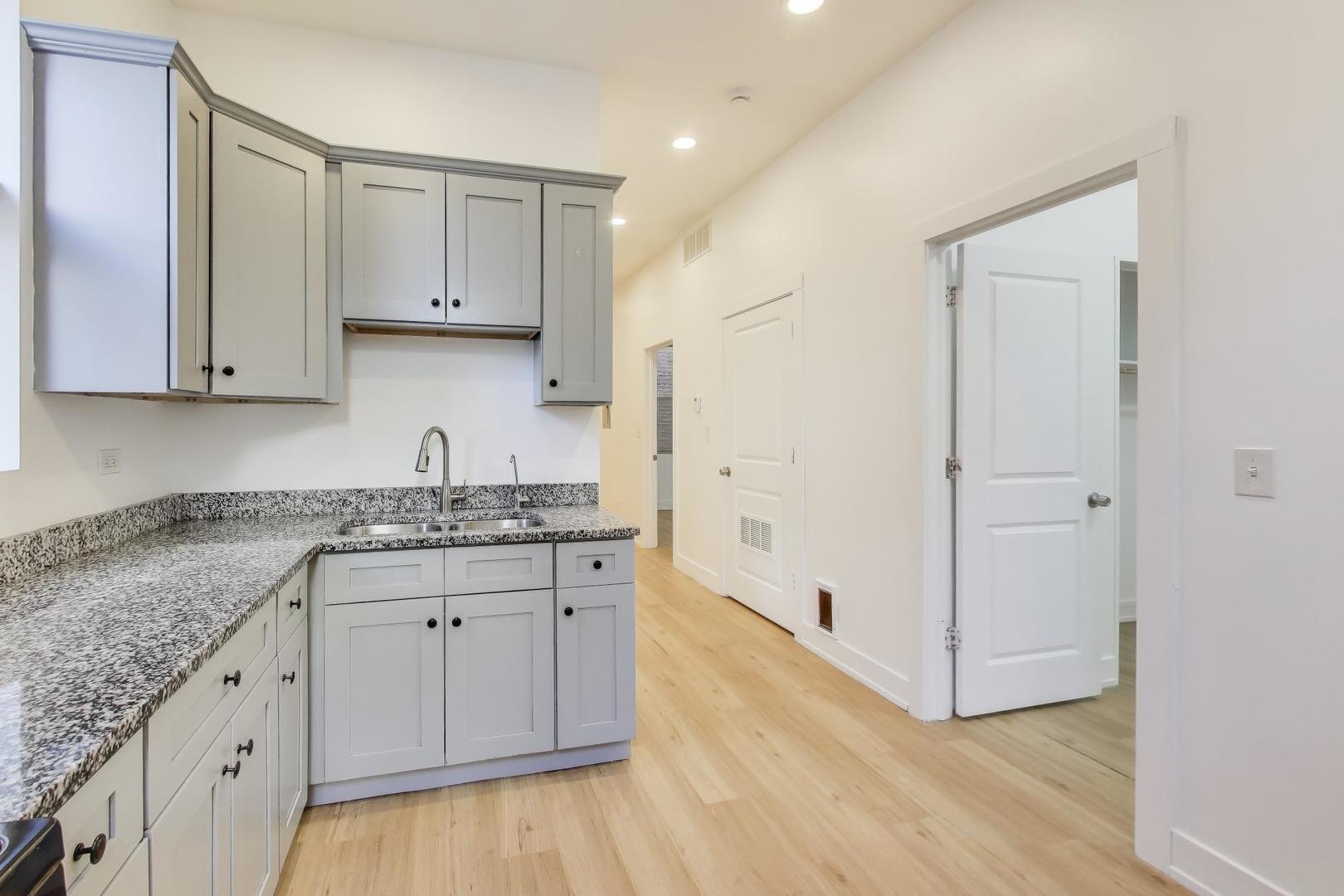 1908 West 48th Street, Unit 1R Chicago, IL 60609 - Photo 9 of 17 a kitchen with granite countertop a sink and a stove top oven
