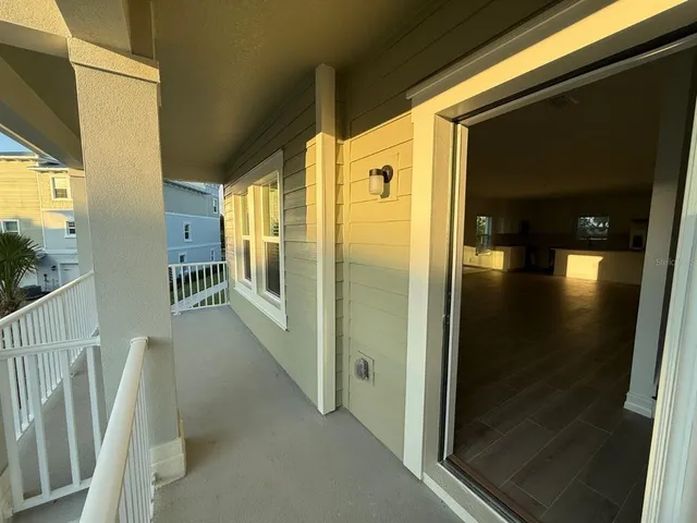 a view of a hallway with wooden floor and windows