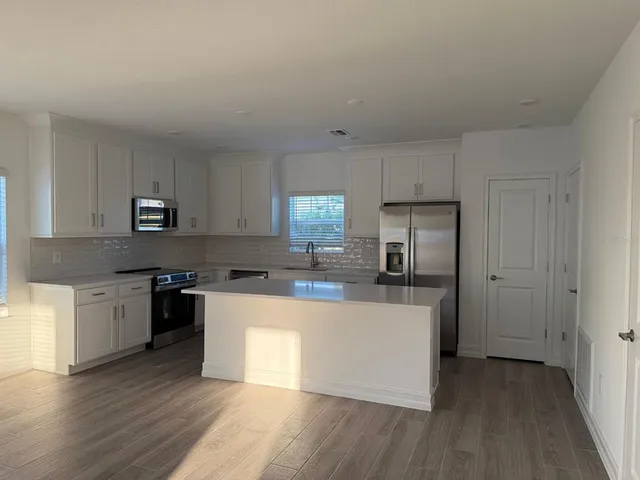 a large kitchen with a stove a sink and a refrigerator