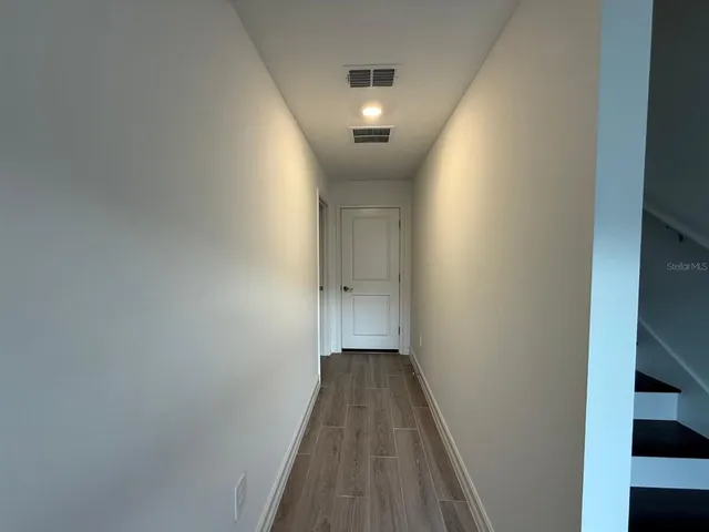 a view of a hallway with wooden floor