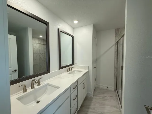 a spacious bathroom with a double vanity sink mirror and double