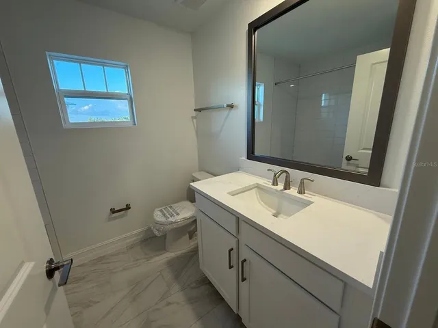 a bathroom with a toilet sink and mirror