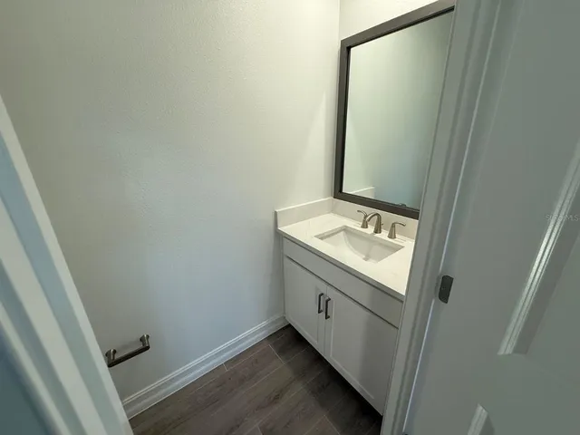a bathroom with a granite countertop sink and a mirror