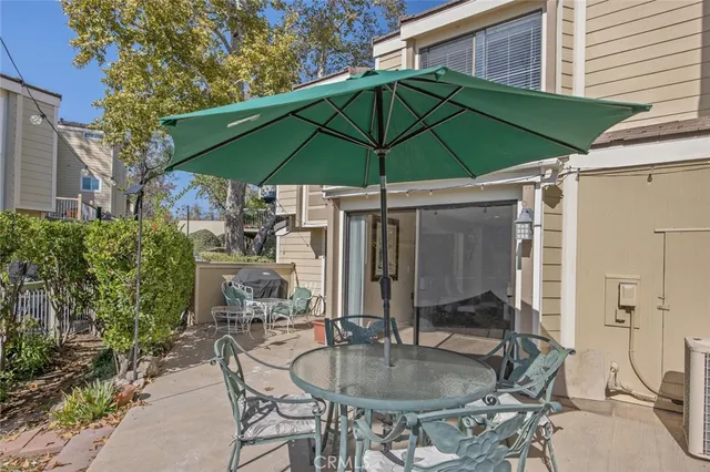 a patio with a table and chairs under an umbrella
