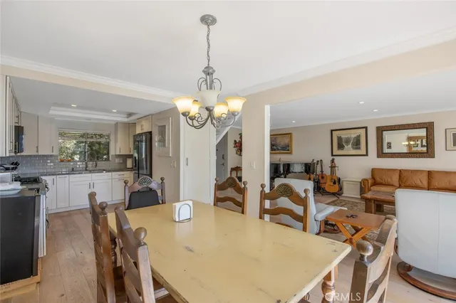 a view of a dining room with furniture a chandelier and wooden floor