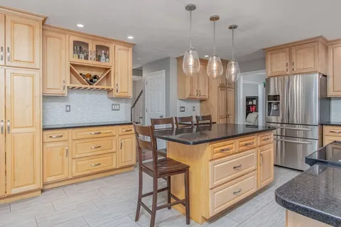 a kitchen with stainless steel appliances granite countertop a stove a sink and a refrigerator