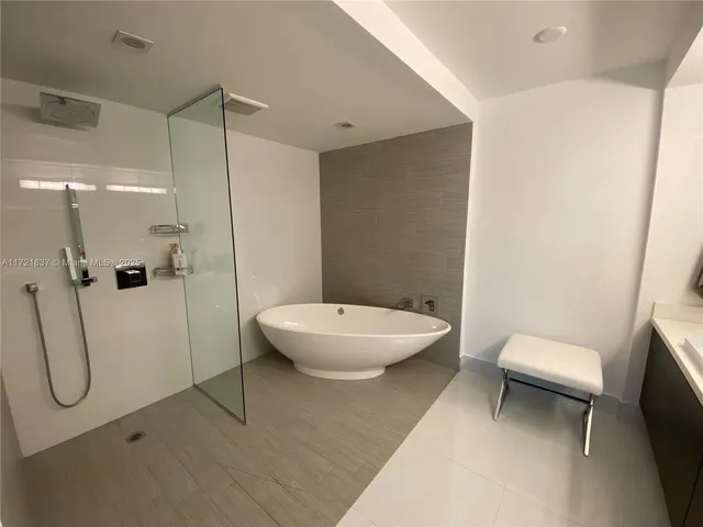 a bedroom with a bed a chandelier and a large window