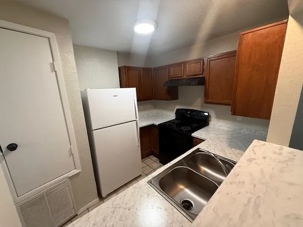a white refrigerator freezer and a stove sitting inside of a kitchen