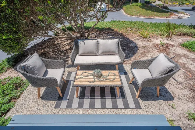 a patio with table and chairs and potted plants