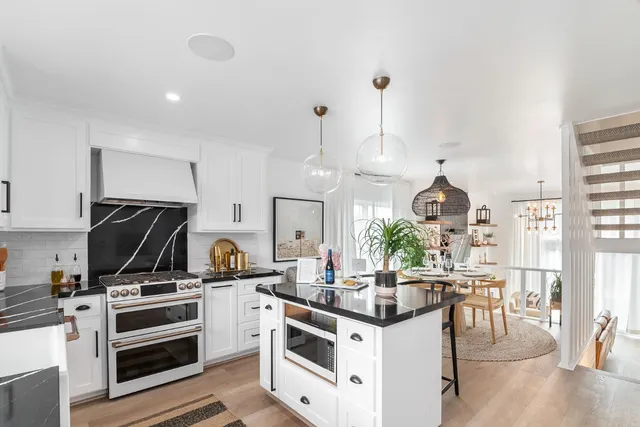 a kitchen with kitchen island a stove and a microwave