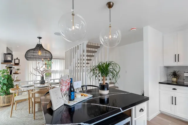 a kitchen with granite countertop a sink dining table and chairs