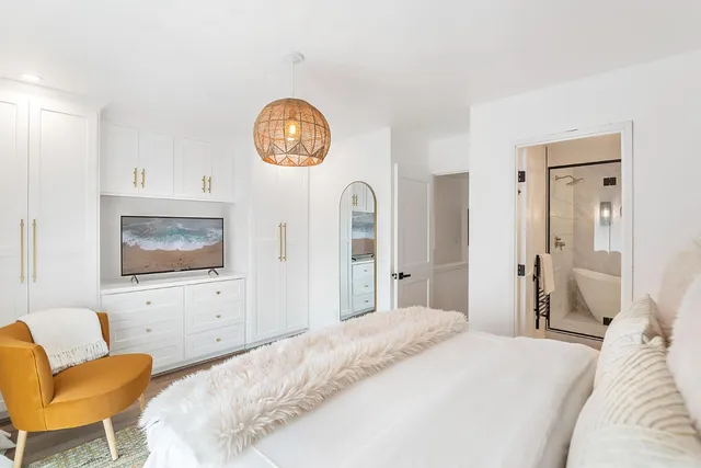 a bedroom with a bed and a chair with the bookshelf