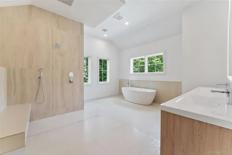 a bathroom with a tub shower and window